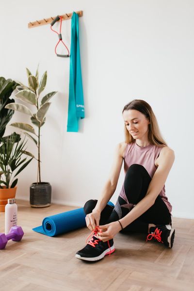 Close-up of comfortable sportswear and a water bottle on a wooden floor.